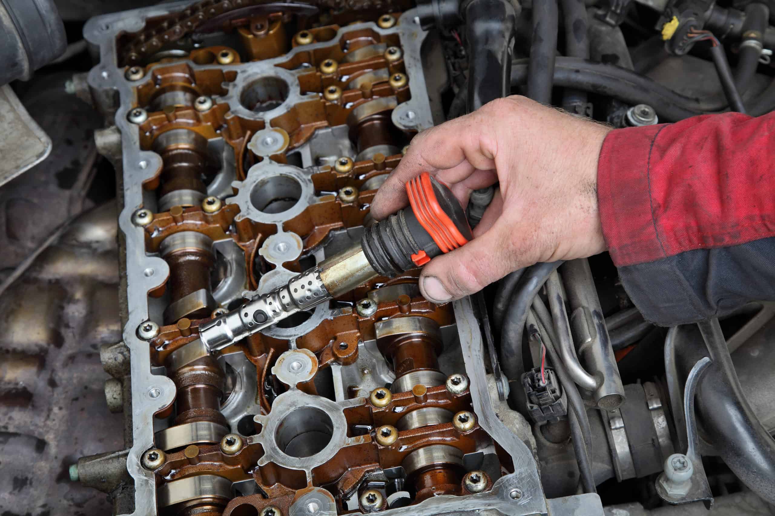 Automotive, mechanic holding ignition coil Automotive, mechanic holding ignition coil