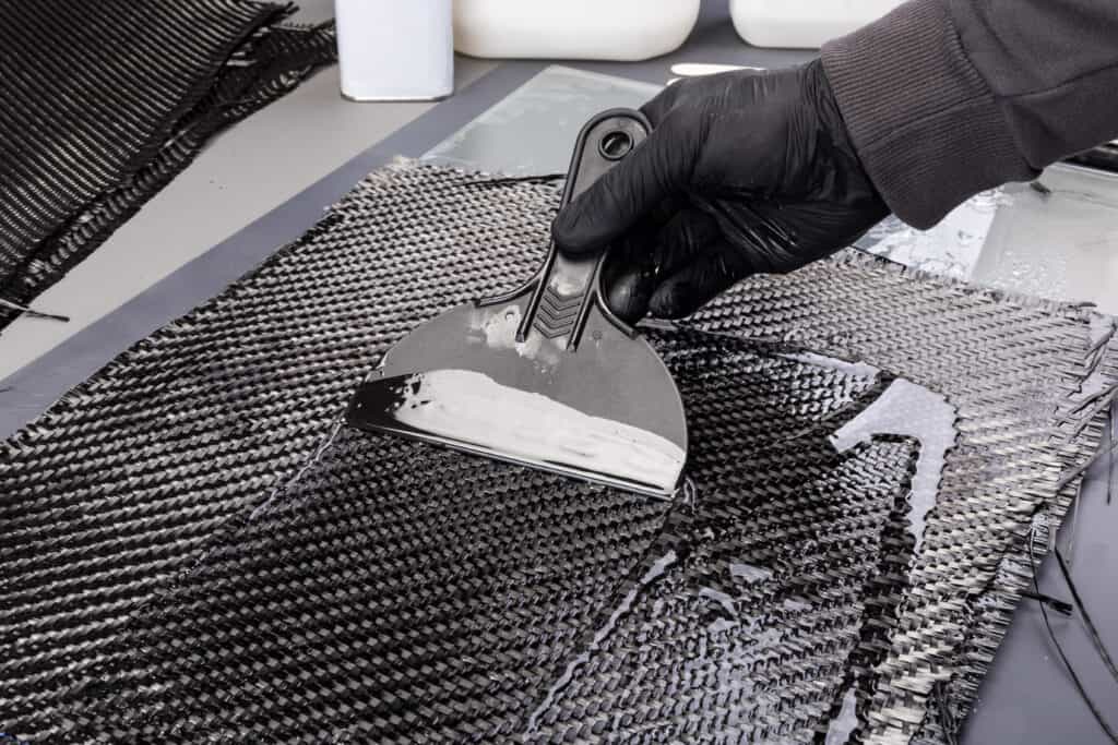 Rolls with various real woven carbon fiber enforcement raw material cloth. composite material automotive and car tuning industry high tech background.