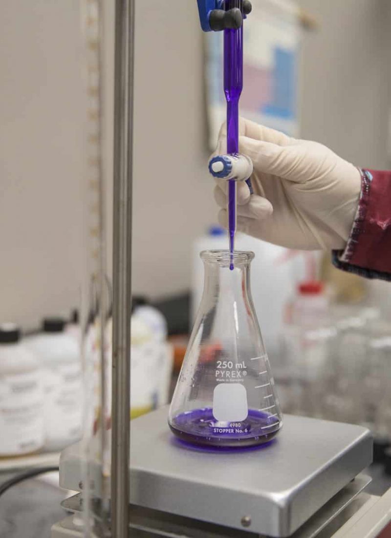 Copps Lab with scientist pouring purple liquid