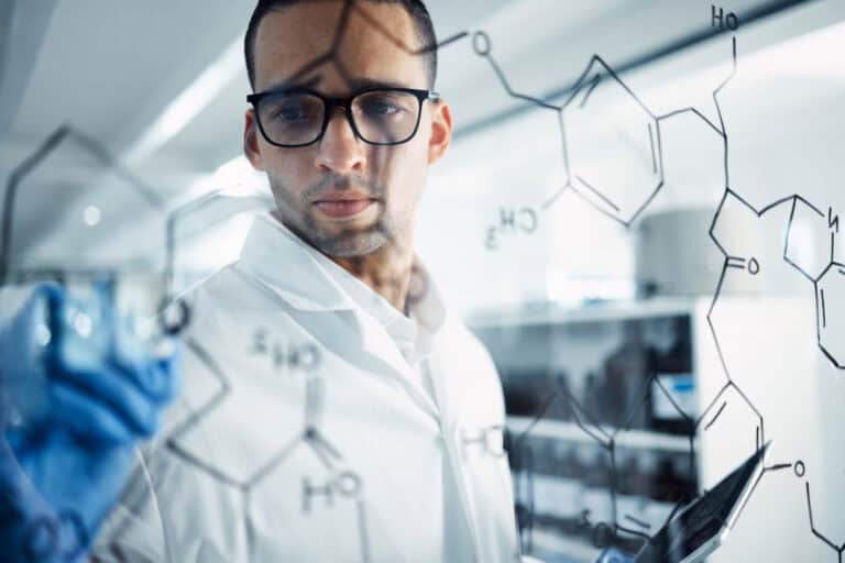 shot of a young scientist solving equations on a glass screen in a laboratory shot of a young scientist solving equations on a glass screen in a laboratory